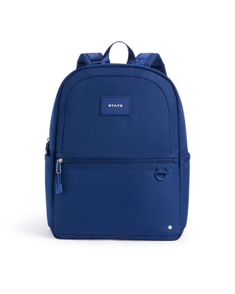 The kane backpack in navy by state bags features a simple and functional design with a front zip pocket, side pockets, and a small STATE patch on the upper front, making it an ideal choice for school.