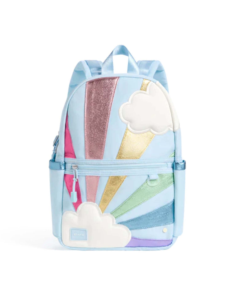 The State Bags Kane Mini Backpack in Rainbow Cloud is a light blue kids' backpack decorated with colorful glittery rays and white cloud patches. It features convenient side pockets, a front zip pocket, and a top handle.
