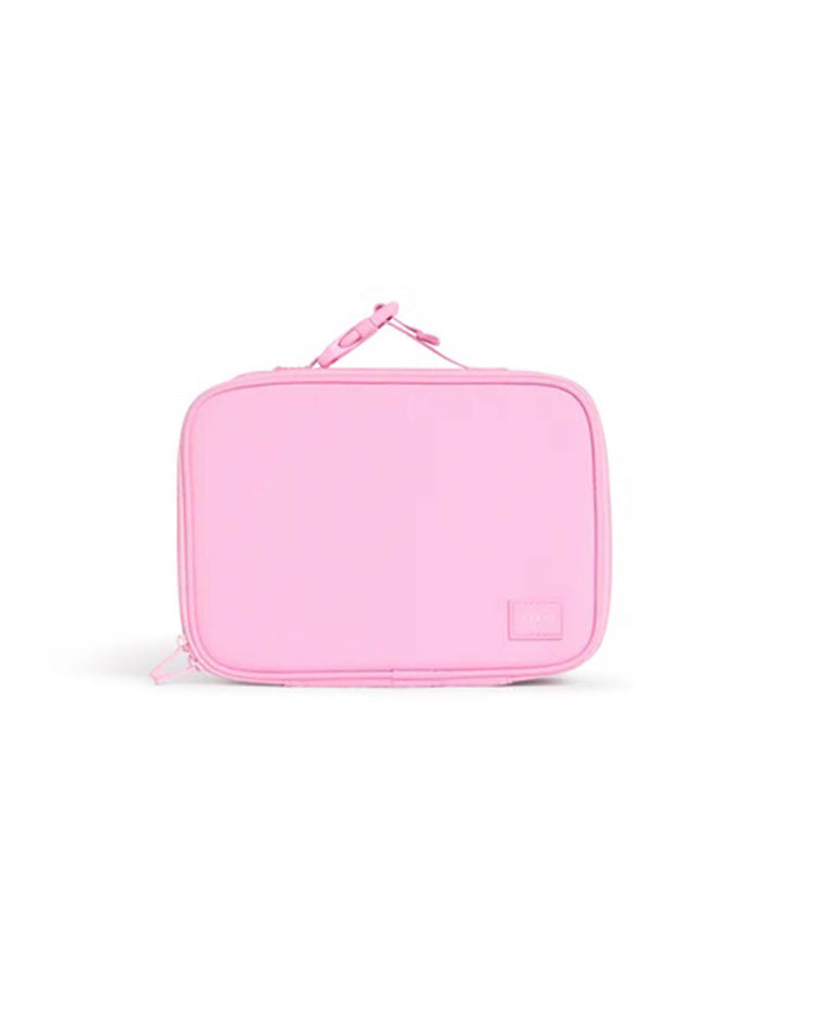 The Rodgers lunch box in pink from State Bags is a rectangular, light pink insulated lunch box featuring a handle on top and a small patch near the bottom right corner, displayed against a white background.