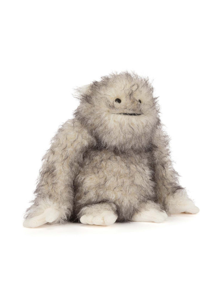The Bretti Yeti by Jellycat is a plush stuffed animal with shaggy gray fur, a round face, dark eyes, stitched smile, and large white hands and feet—an adorable soft toy suitable for all ages.