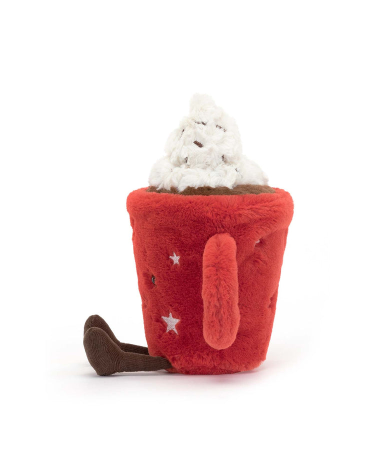 A charming plush toy resembling a cozy mug with star patterns, filled with a white whipped cream-like topping and a small brown handle, just like the Jellycat Amuseable Hot Chocolate.
