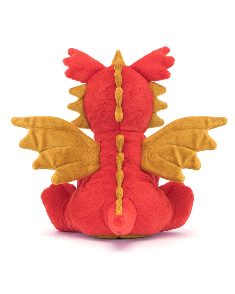 Viewed from the back, the Darvin Dragon plush by Jellycat showcases striking red and orange hues, complete with wings, a spiked tail, and a line of spines along its back. This soft toy makes an adorable stuffed animal companion for any dragon enthusiast.