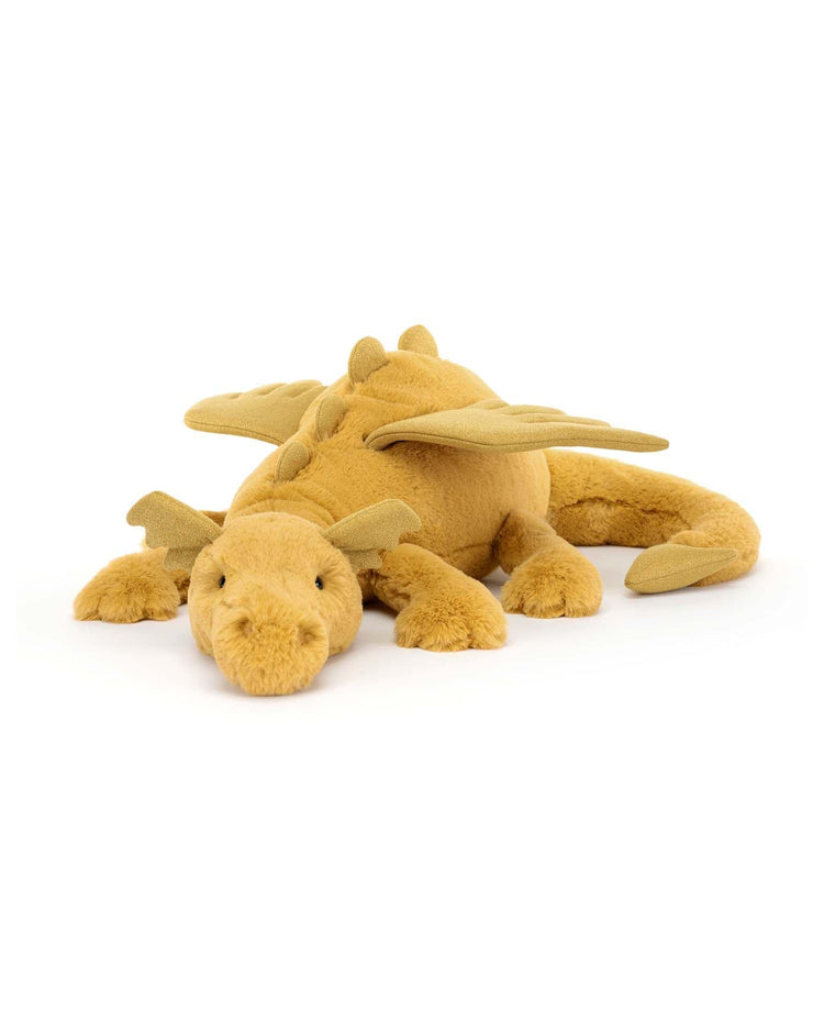 A Jellycat Golden Dragon plush toy, featuring gold-brown fur, small wings, and a tail, lies flat on a white background, ready to inspire magical dreams.