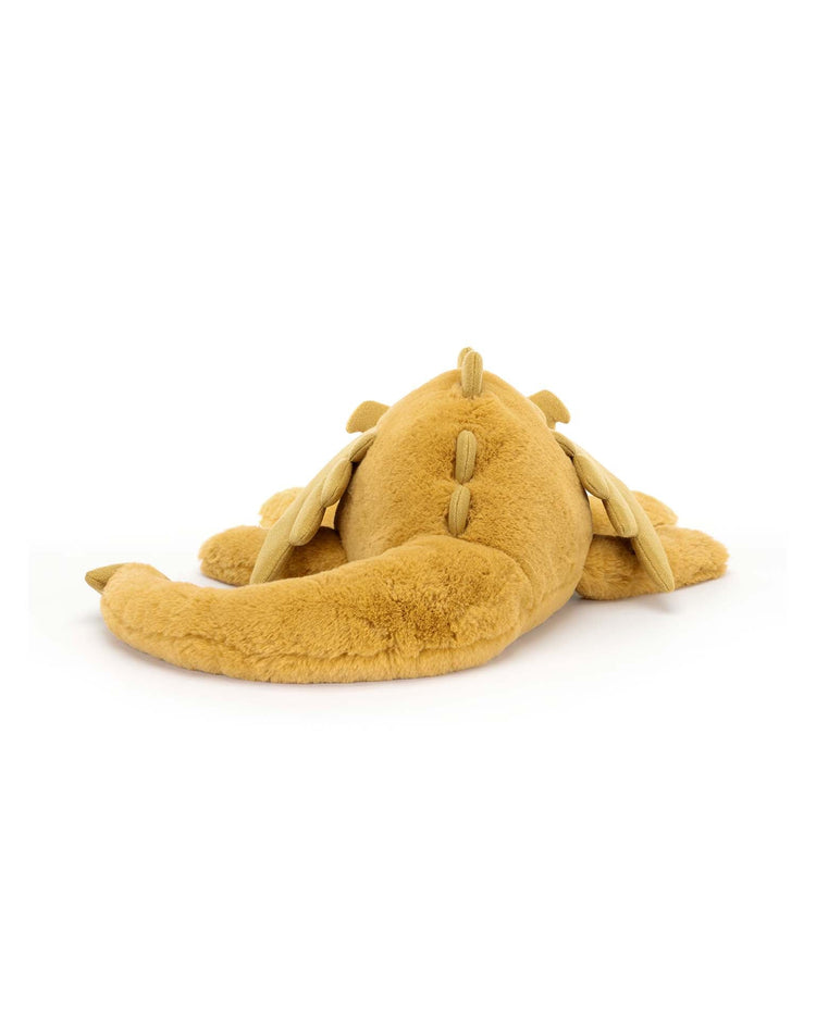 A Jellycat Golden Dragon plush stuffed animal lies on its belly with legs splayed out and tail extended, ready to embark on magical dreams. This enchanting stuffed animal promises endless adventures and cozy companionship.