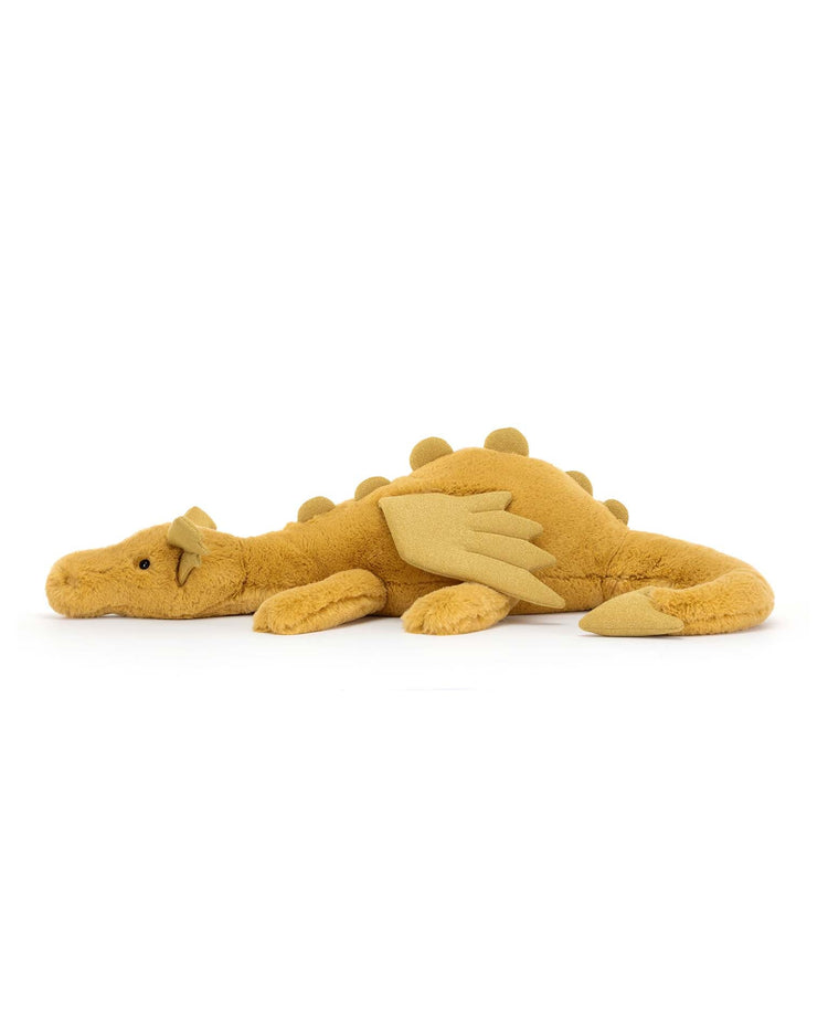 A soft, plush toy dragon from Jellycat with golden yellow fur, small wings, and a row of round spikes along its back, the Golden Dragon lies on its belly, ready to inspire magical dreams.