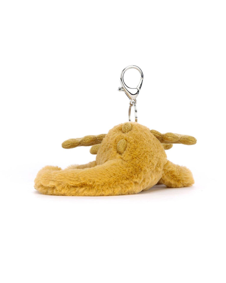 A golden dragon bag charm by Jellycat, featuring a plush design and a metallic clasp at the top, on a white background.