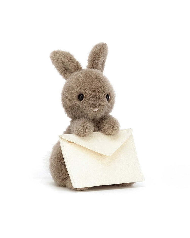 The messenger bunny by jellycat is an adorable gray plush bunny that clutches a white envelope with its paws, making it perfect for delivering a personal message.
