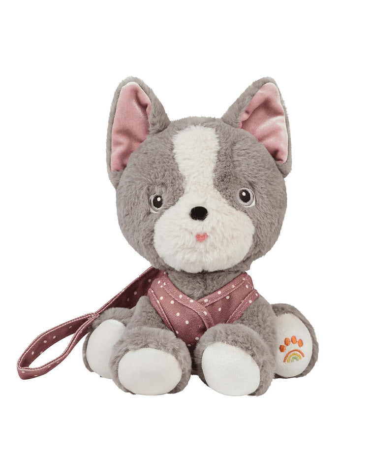 The dinkum dolls dinkum dog gizmo is a plush recycled dog toy with big eyes, pink inner ears, a pink harness with white polka dots, matching leash, a rainbow paw print on the left foot, and comes with a magnetic bone accessory.