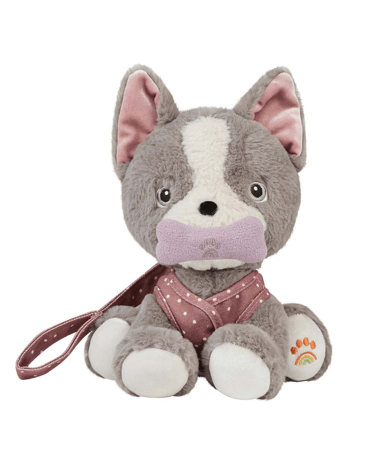 Dinkum dog gizmo by dinkum dolls is a plush recycled dog toy with gray and white fur, a pink polka-dot harness, magnetic bone accessory, and a rainbow with paw print design on its left paw.