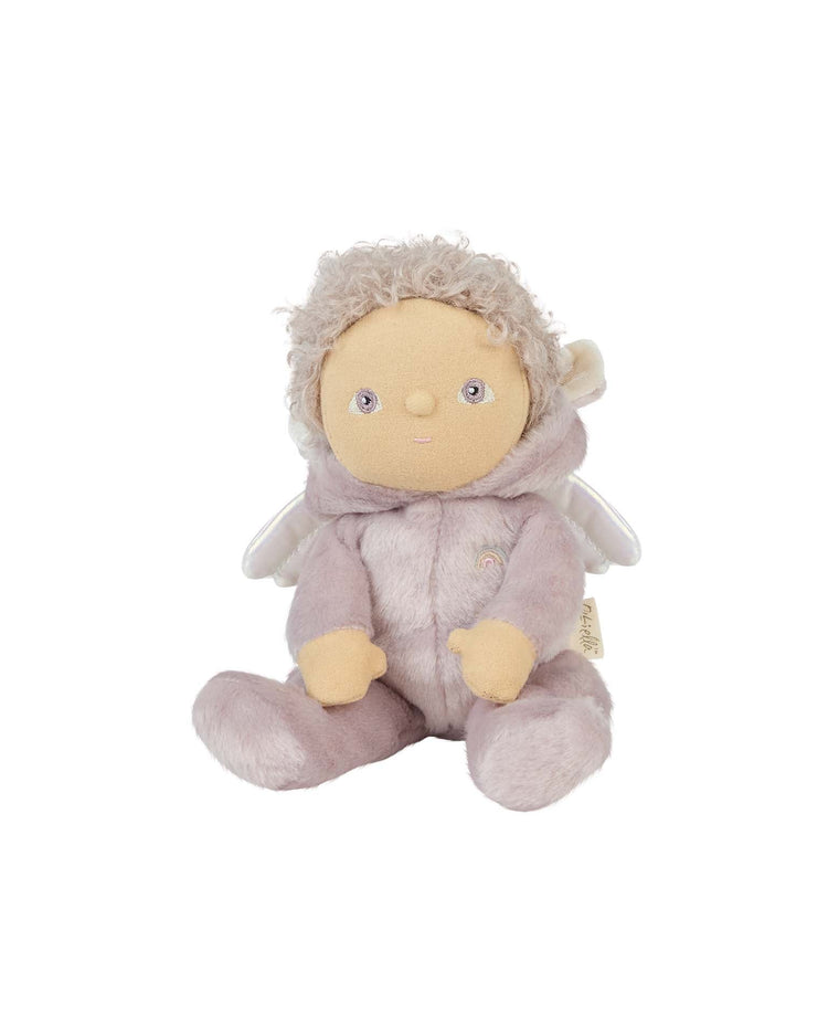 The Dinkum Dolls dinky dinkum doll Uma Unicorn Lilac is an adorable plush with a beige face, round eyes, short curly hair, small wings, and a soft lilac suit—perfect for sitting upright on display.