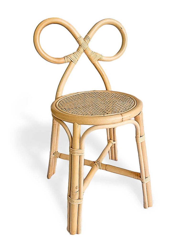 The Poppie Bow Chair by poppie toys features a circular woven seat and an ornate, looped backrest evocative of a bow or infinity symbol—ideal as a kids chair or vanity chair—shown here against a white background.