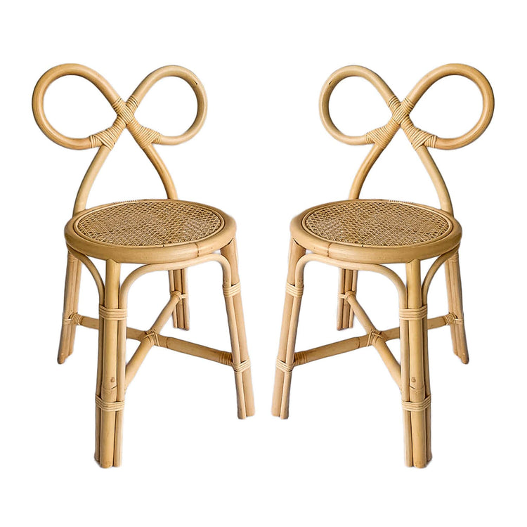 Two Poppie Bow Chairs by poppie toys, featuring looped sculptural backrests and woven cane seats, are displayed side by side against a white background—stylish kids’ chairs for any modern space.