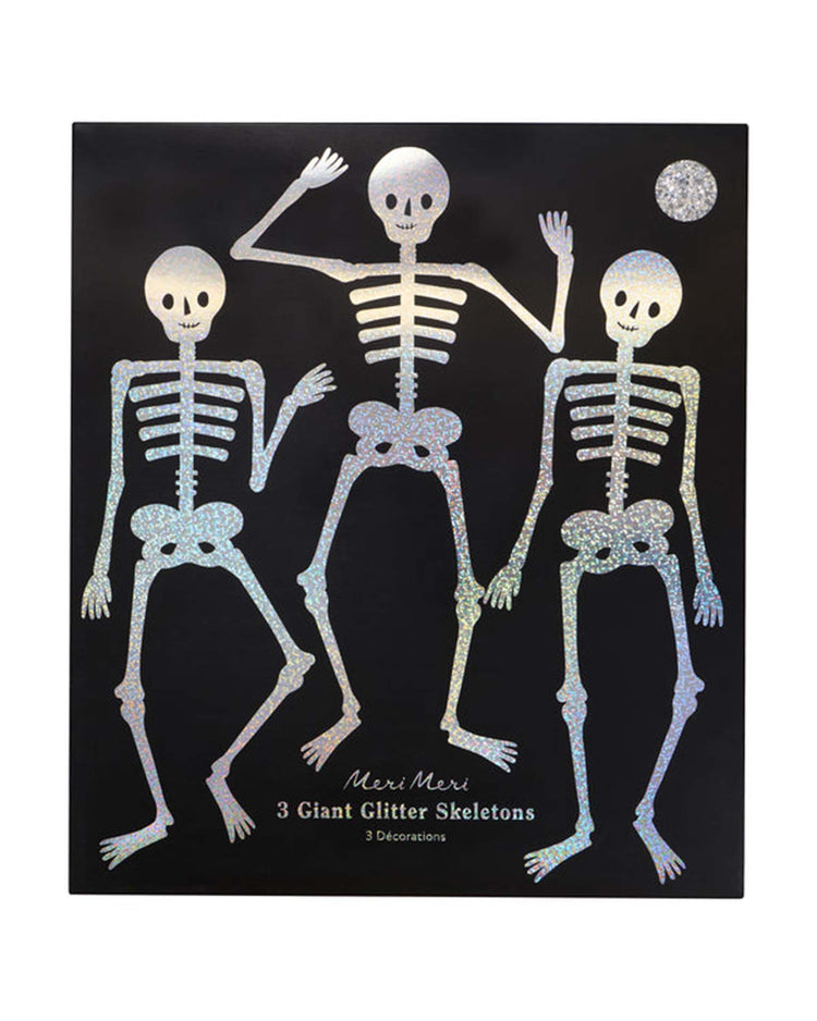 Three giant glitter jointed skeleton decorations from Meri Meri, each in a unique pose, are displayed on a black background—perfect for adding a spooky and sparkling touch to your Halloween party decor. The text reads: “Meri Meri Giant Glitter Jointed Skeleton Decorations, 3 giant skeletons.”.