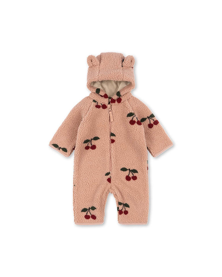The jody teddy onesie in ma grande cerise blush by konges sløjd is a pink fleece baby onesie made from recycled polyester, featuring a hood with cute bear ears and an all-over cherry print pattern, shown on a white background.
