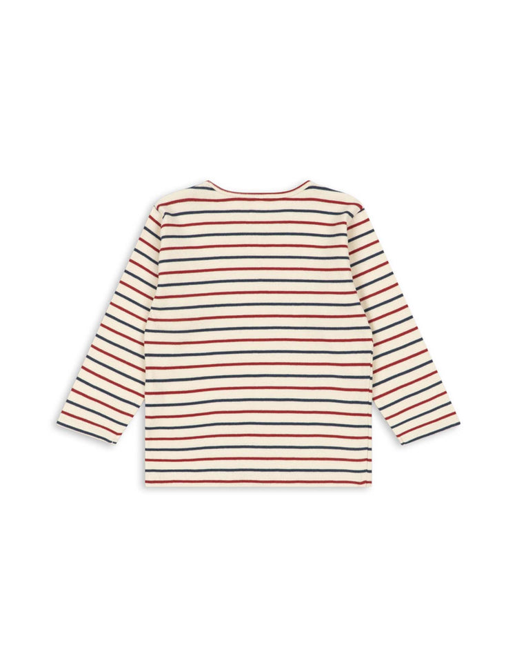 The voco modal blouse in tricolore bleu by konges sløjd is a long-sleeve shirt made from a soft modal blend, showcasing horizontal stripes in red, navy blue, and beige on an off-white background, displayed from the back.