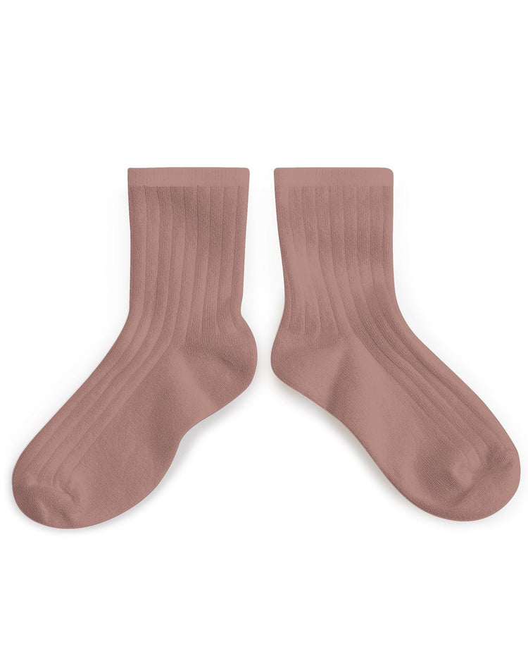 A pair of pink, ribbed Collegien la mini ankle socks in Praline de Lyon isolated on a white background.