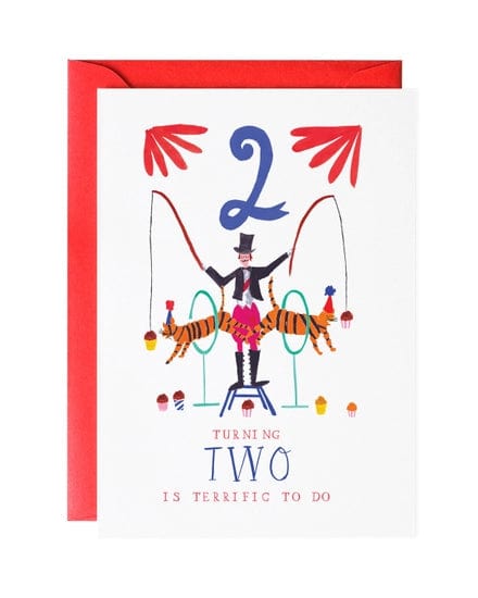 A birthday card from Mr. Boddington's Studio called "Two Tiger Twins Greeting Card," featuring a circus theme with a ringmaster and two tigers, and the text "Turning two is terrific to do." The card comes with a red envelope.