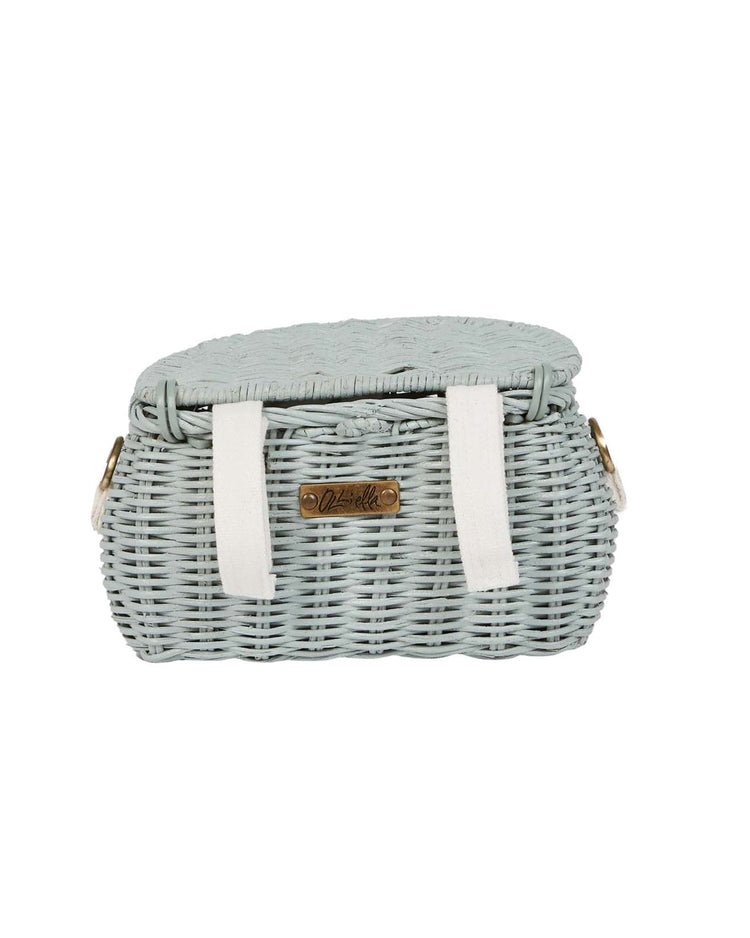 The dinkum dolls mini chari bag in vintage blue features a light blue woven wicker design, hinged lid, white straps, and a metal label—perfect for carrying little essentials in style.