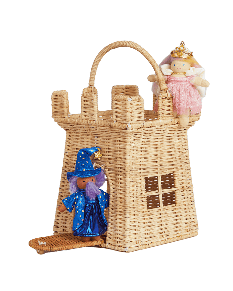 A handwoven dinkum dolls rattan castle bag with a handle, featuring a plush wizard in blue at the doorway and a plush princess in pink on top.