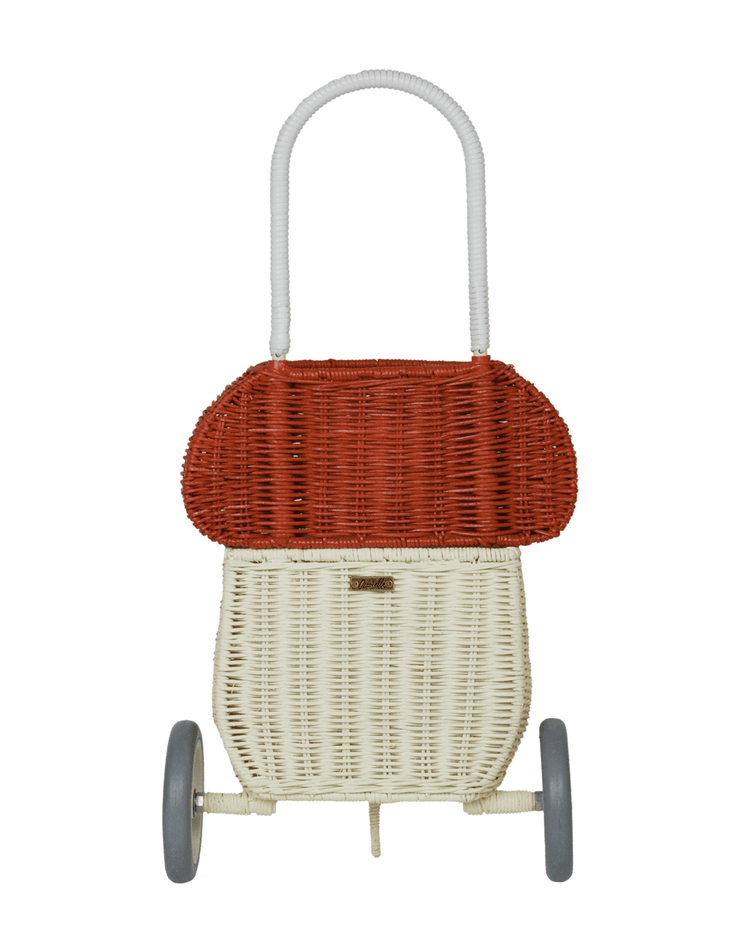 The dinkum dolls rattan mushroom luggy in red features a red top, white bottom, gray wheels, and a white handle—ideal for toy storage—and is photographed against a plain background.