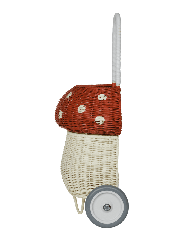 The dinkum dolls rattan mushroom luggy in red features a white base, red top with white spots, and a tall white handle—perfect for playful toy storage and easy mobility.