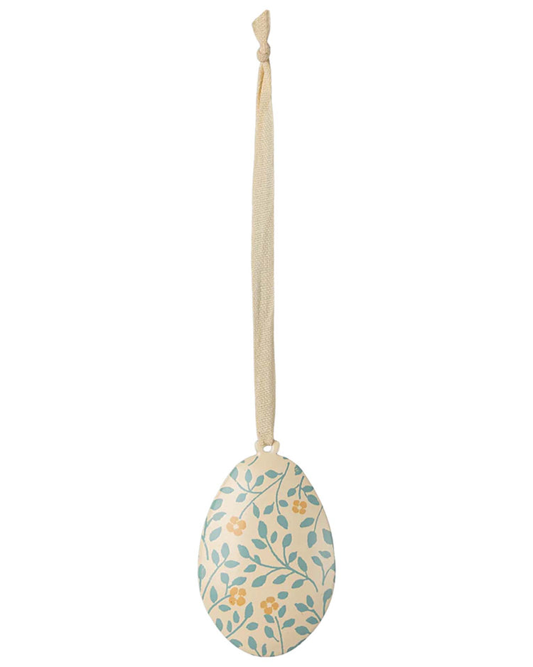 The branches Easter egg ornament by Maileg features a charming blue and yellow flower print design, reminiscent of Easter eggs, and is hung by a delicate beige ribbon.