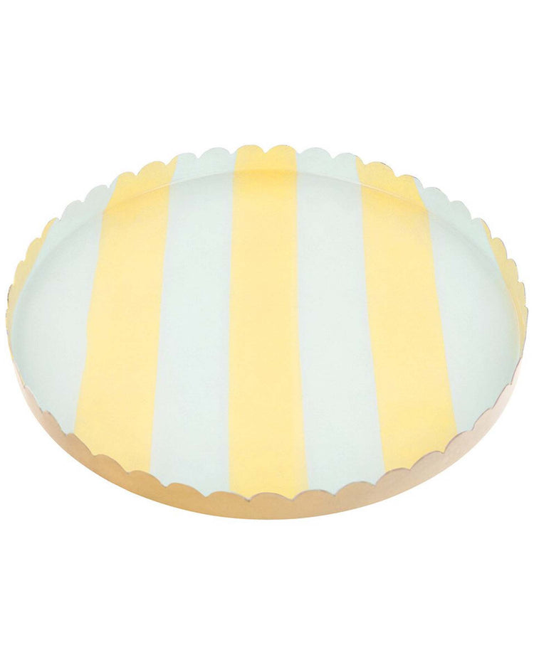 The meri meri pastel striped medium accessory tray is a round metal tray with a scalloped edge, featuring alternating pastel yellow and light blue vertical stripes on its enamel finish.