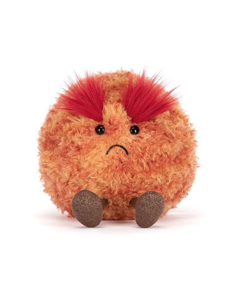 A round, orange amuseables planet mars plush by jellycat with angry red eyebrows, small black eyes, a sad frown, and two brown feet is sitting on a white background.