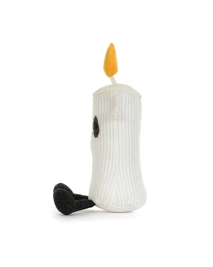 The amuseables flickerty candle by jellycat is a plush toy designed to resemble a white candle with a yellow flame on top and a black wick at the base; this charming candle plush makes a delightful addition to spooktacular tablescapes and is perfect for any Halloween party planner, shown on a plain white background.