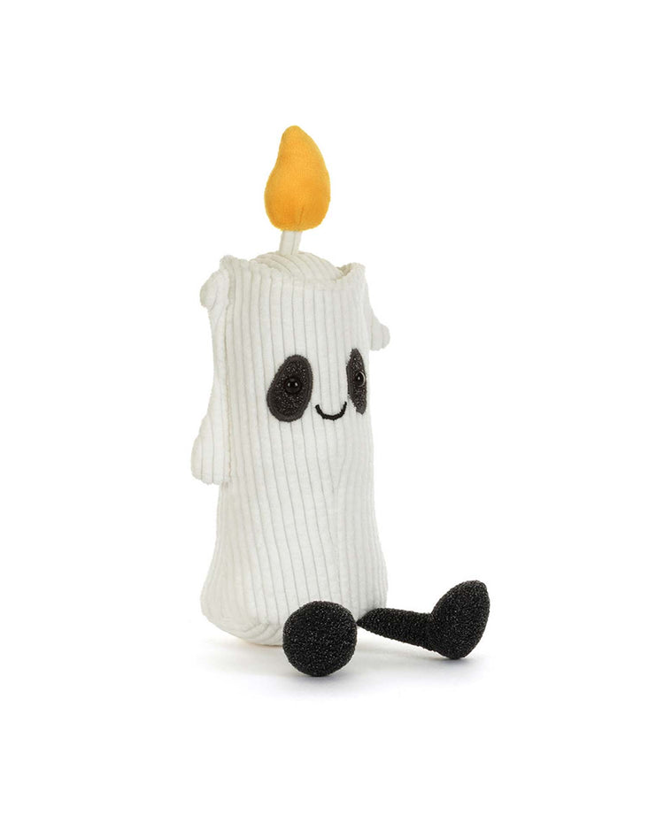 The amuseables flickerty candle by Jellycat—a plush toy designed as a white candle with a yellow flame, black arms and legs, and a cheerful smile—sits upright against a white background, making it an adorable centerpiece for any Halloween party planner aiming to create spooktacular tablescapes.