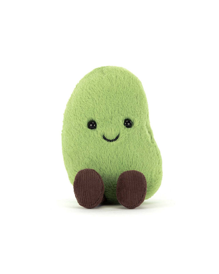 The Jellycat Amuseables Soyella Edamame Bean is a soft green plush toy shaped like a bean, with embroidered eyes, a smile, and two brown feet, shown sitting upright on a white background.