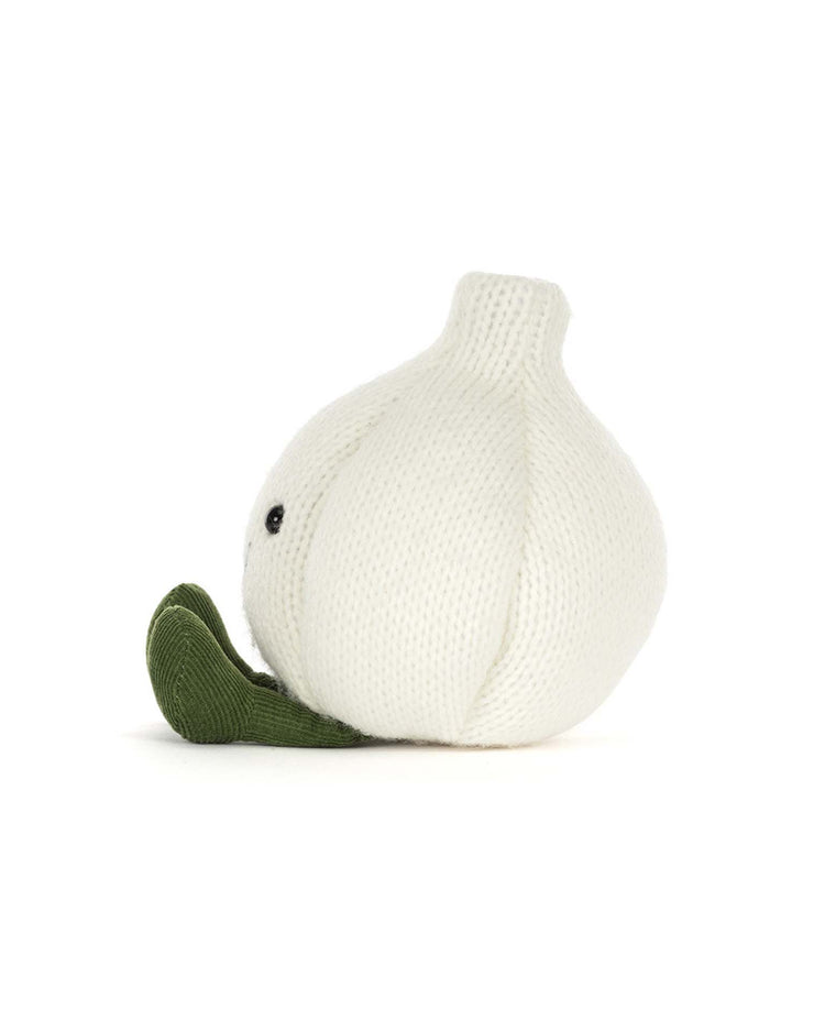 A plush toy from Jellycat’s Amuseables Garlic collection, featuring a knitted white garlic bulb with a green felt leaf and embroidered black eyes, shown in profile on a white background—an ideal accent for your next Halloween party.