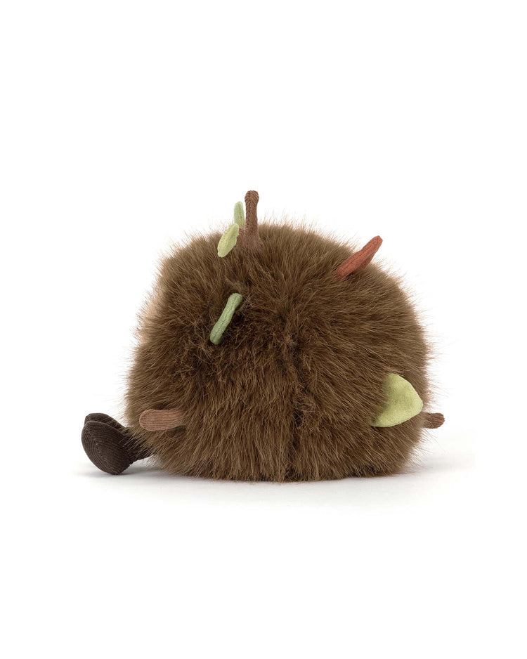 A round, brown plush toy from Jellycat’s Amuseables Mulshi Woodland Floor collection, featuring small colored spikes and a dark brown tail, resembling a whimsical woodland creature, shown on a plain white background.