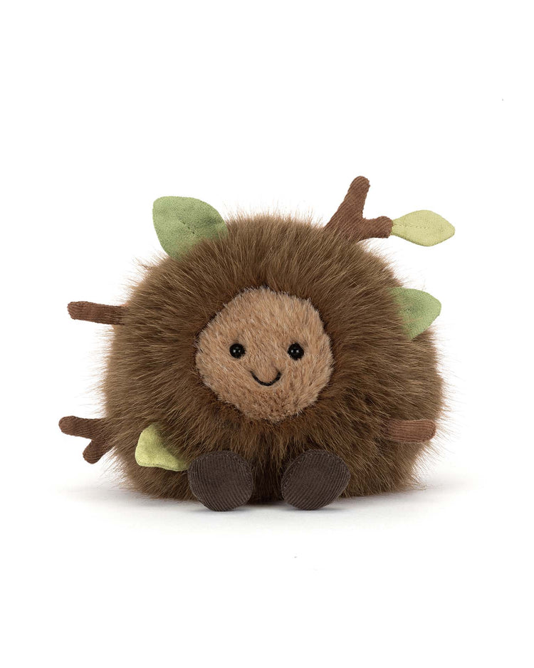 The Jellycat amuseables mulshi woodland floor is a round plush toy with brown fur, a smiling beige face, brown feet, soft fabric branches, and green leaves—resembling a cute woodland creature—shown against a white background.