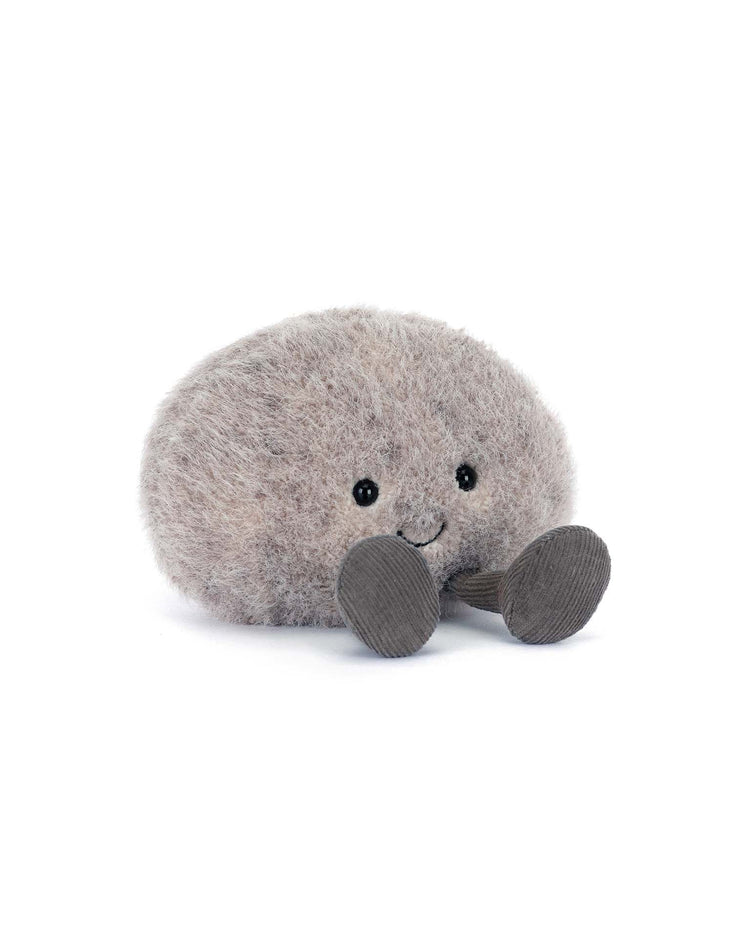 The Jellycat Amuseables Pebble is a soft, round, gray plush toy with black button eyes, a small smile, and two flat dark gray legs—an adorable companion for any adventure. Displayed on a plain white background.