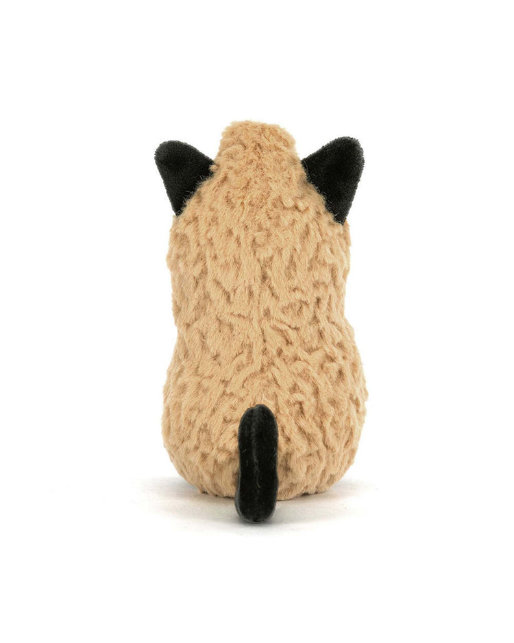 A plush toy from Jellycat, named the Amuseables Peanut Cat Outfit, is shown from behind with tan fur, black ears, and a black tail—all set against a white background.