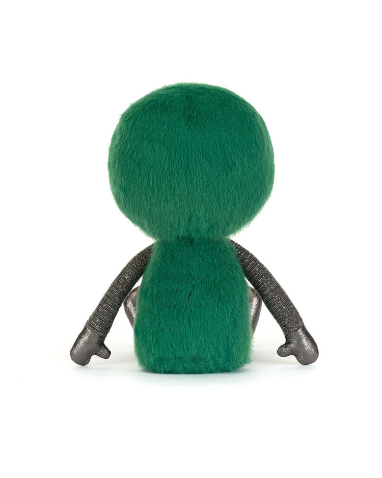 The zyllan alien plush toy by jellycat features a round green furry head and body, black textured arms, and small black hands, shown sitting with its back facing the viewer.
