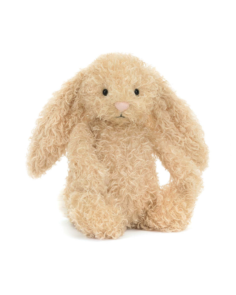 The Jellycat Bashful Luxe Bunny Curly Original features plush beige curly fur, floppy ears, black button eyes, and a fluffy cream bobtail—an adorable cuddling companion that sits upright against a white background.