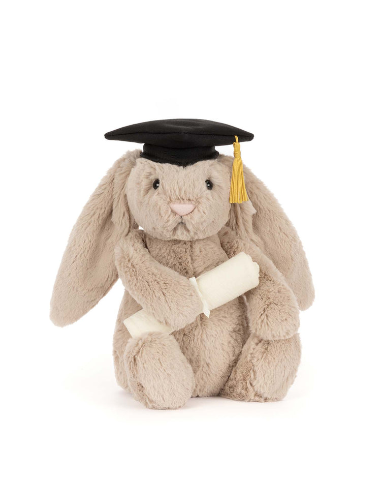 The Jellycat Bashful Bunny Graduation Outfit features a plush bunny in a black graduation cap with yellow tassel, holding a diploma—an adorable and perfect gift for any celebration.