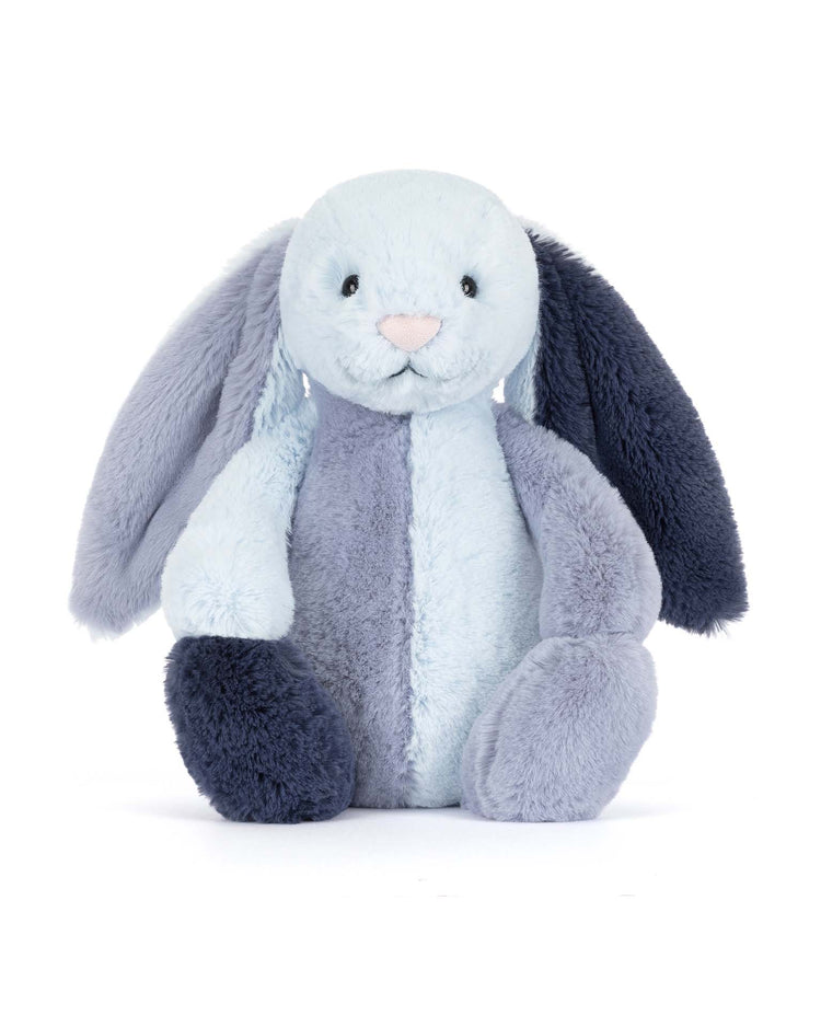 The jellycat puddlesea bunny original is a plush toy with two-tone blue fur, one light and one dark blue ear, a pale blue face and body, and a small pink nose—adorable and perfect as a beach companion.