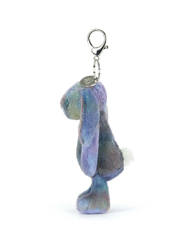 The Jellycat Zodihop Luxe Bunny Bag Charm features soft, multicolored blue, purple, and gray fur, long ears, a white tail, and a silver keyring—making it a cute upright accessory for your bag.