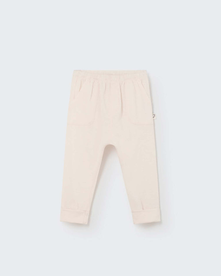Cairo baby pant in ivory by My Little Cozmo: Organic cotton children's pants with an elastic waistband and folded cuffs, inspired by European styles and crafted in Barcelona. Displayed on a plain background.