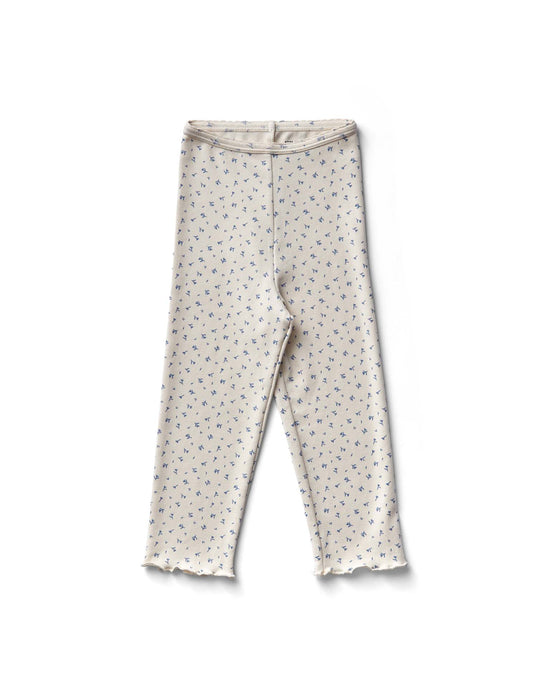 The capri legging in frolic print, blueberry by Soor Ploom, features a cream color with small blue florals and a ruffled hem, made from cotton sourced from Peru.
