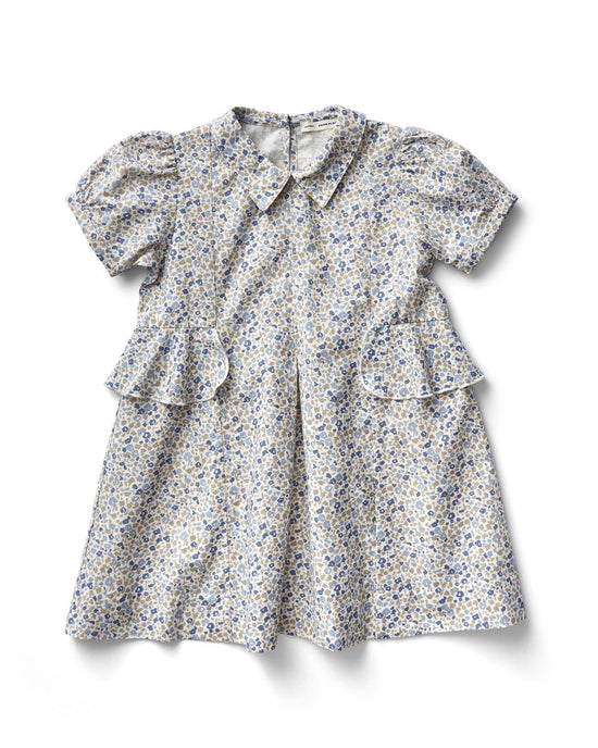 The soor ploom celia dress in menagerie print, blueberry, displays a floral pattern with a Peter Pan collar and ruffled accents on the sides, all crafted from soft cotton, against a plain background.
