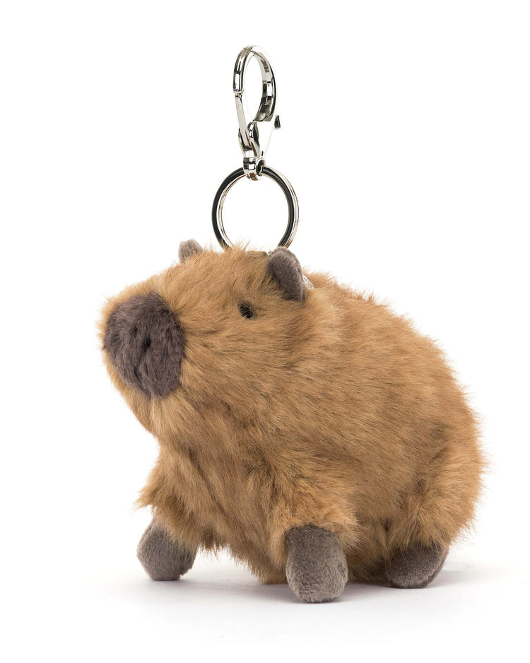 Meet the Jellycat Clyde Capybara Bag Charm! This plush keychain has soft brown fur and gray feet, featuring a silver claw clip. It's the perfect accessory to add personality to your bag.