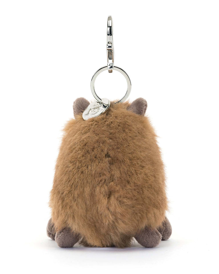 The Clyde Capybara Bag Charm by Jellycat is a fluffy, brown keychain with soft fur and small ears, attached to a metal ring.