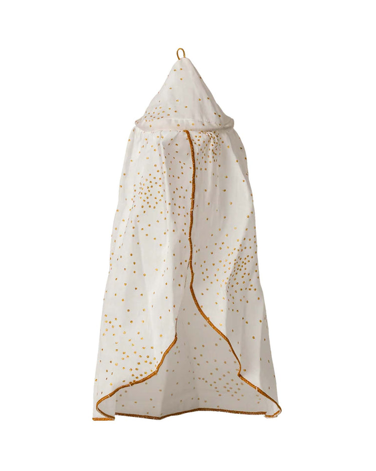 The maileg miniature bed canopy in off white features a pointed top, gold dotted pattern, and gold trim. Ideal for dollhouses or as a decorative children’s room accessory with its charming tent-like design.