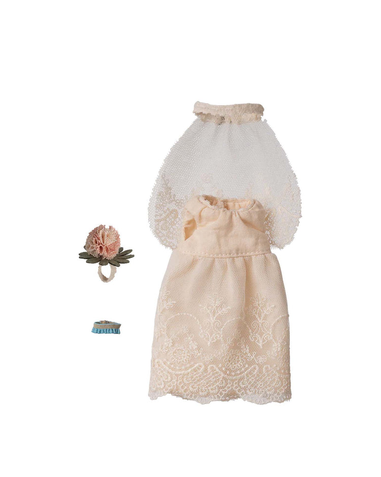 The Maileg wedding dress for mum mouse features a lace bridal gown, matching veil, floral headpiece, and blue garter—delicate bride accessories—beautifully arranged on a white background.