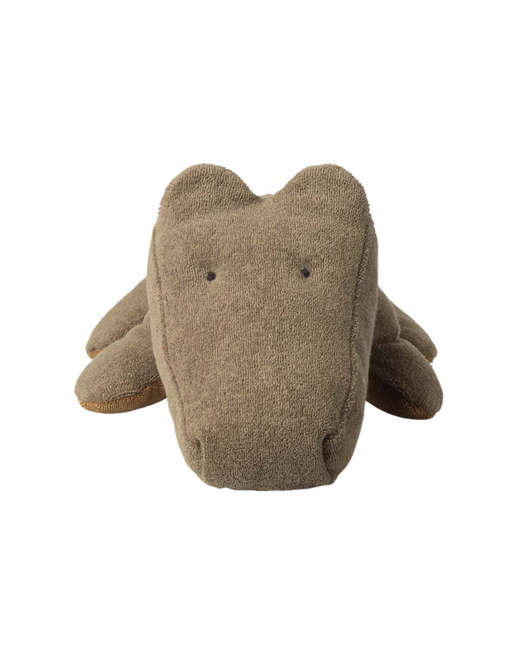 The “medium crocodile in olive green” from maileg's safari friends is a cotton plush toy shaped like an alligator, shown from the front on a white background, with minimal details—small stitched eyes and a simple, rounded snout.