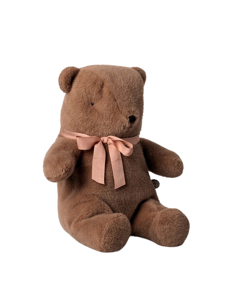 The maileg medium teddy bear plush in soft brown features a soft texture and a light pink ribbon bow around its neck, sitting upright against a white background.
